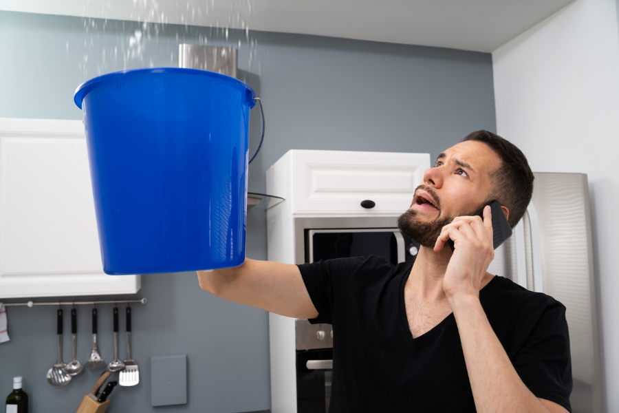 Emergency water damage response - placing bucket under roof leak