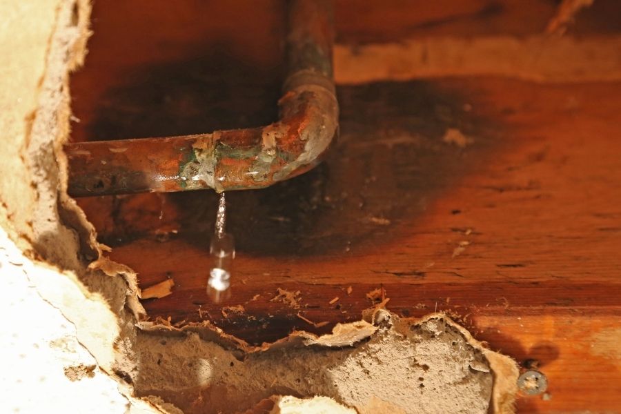Burst pipe spraying water inside a residential wall or ceiling