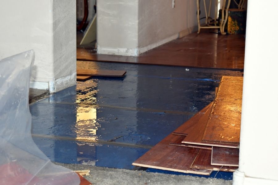 Water-damaged flooring showing warping and discoloration following a disaster