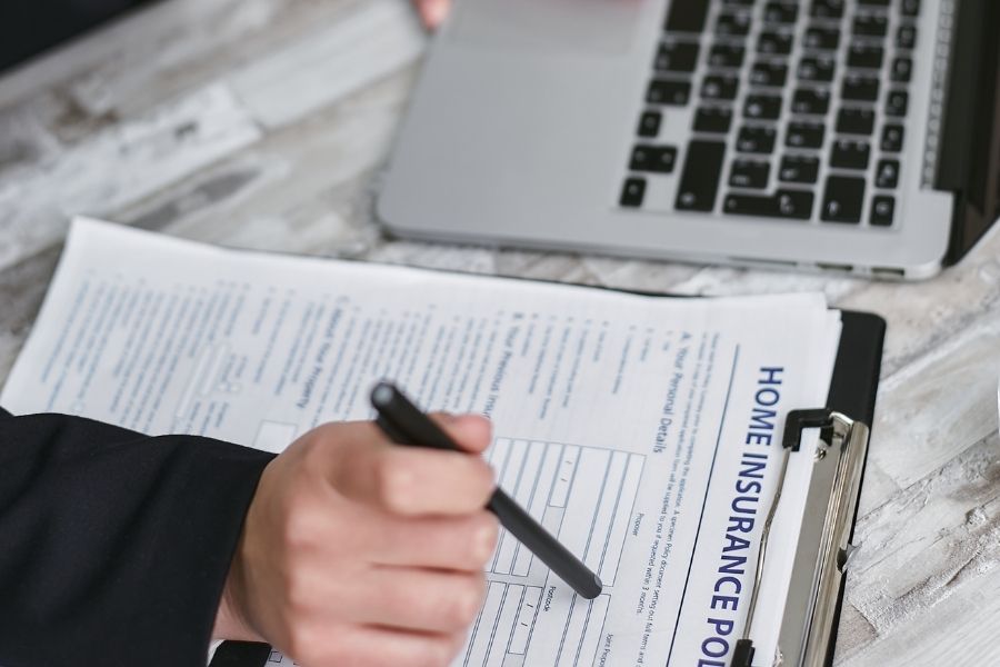 Homeowner reviewing insurance policy documents at their kitchen table