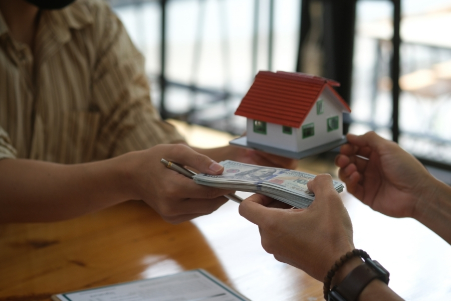 Insurance settlement check and homeowner deciding how to use claim funds for home repairs